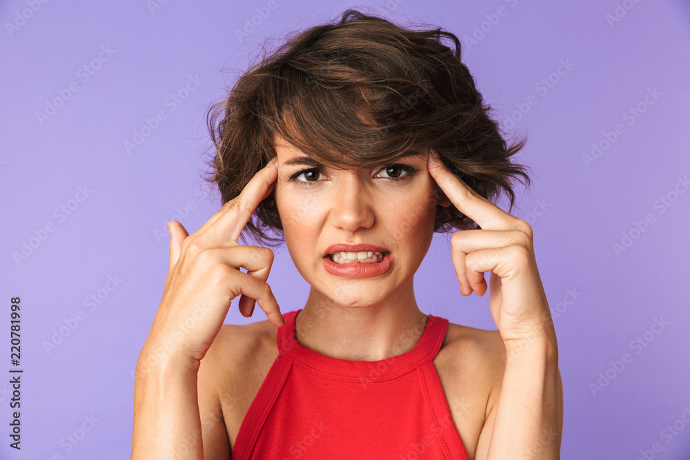 Image closeup of upset young woman 20s in casual wear frowning and touching temples, isolated over violet background
