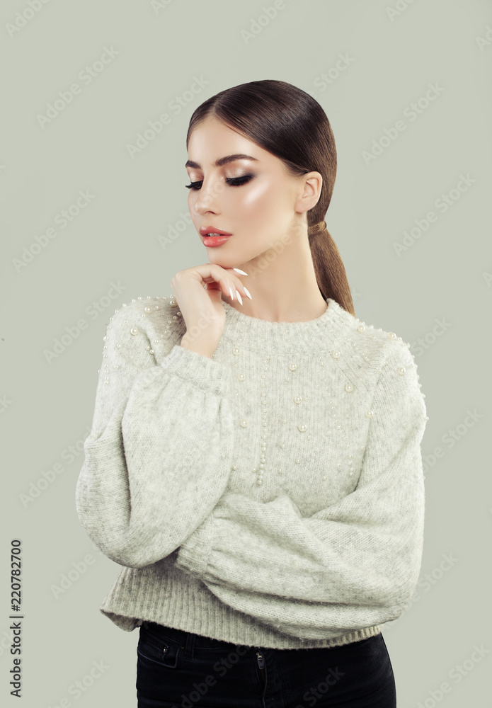 Young pensive woman on gray background, portrait Young pensive woman on gray background, portrait