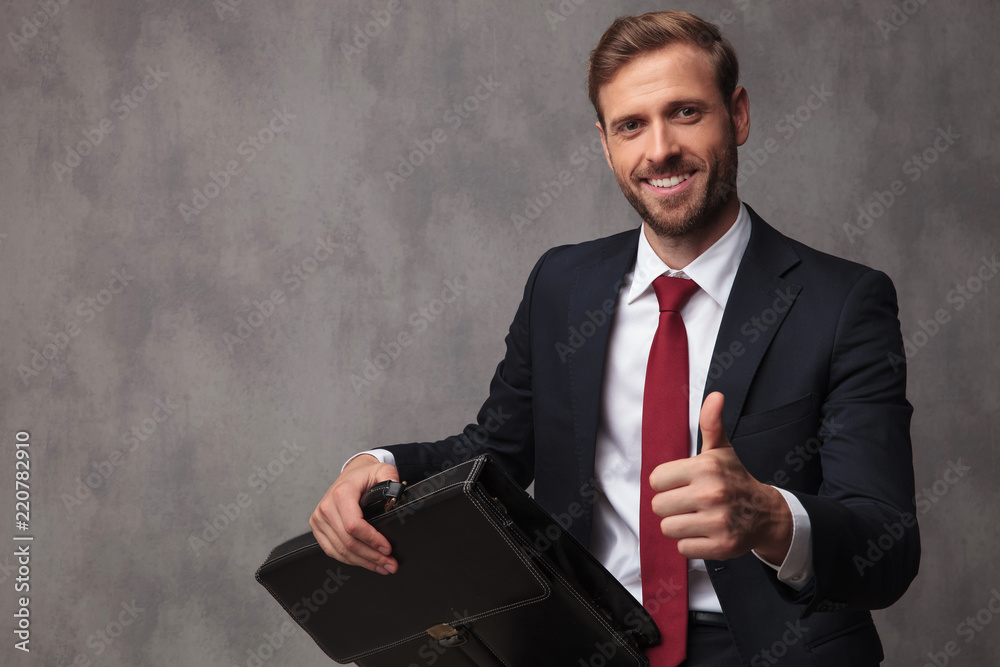 seated businessman holding briefcase makes ok sign seated businessman holding briefcase makes ok sign