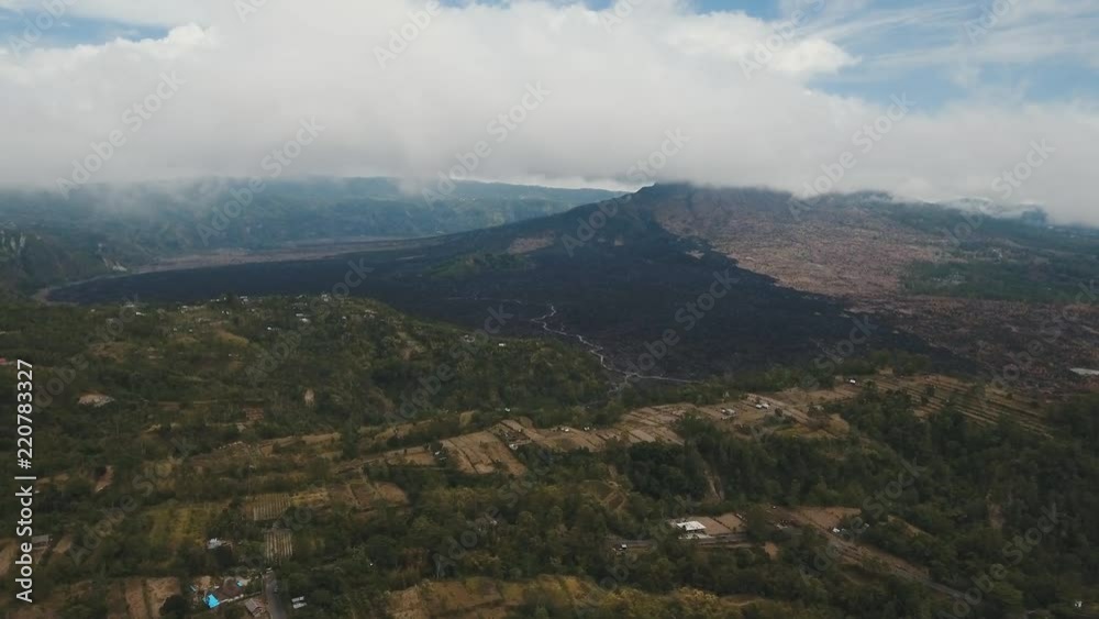Volcano, mountains, sky with clouds, traces of lava on the ground. Aerial view of Mount Batur Volcano in Kintamani. Bali volcano, also referred to as Kintamani is popular sightseeing destination in Volcano, mountains, sky with clouds, traces of lava on the ground. Aerial view of Mount Batur Volcano in Kintamani. Bali volcano, also referred to as Kintamani is popular sightseeing destination in