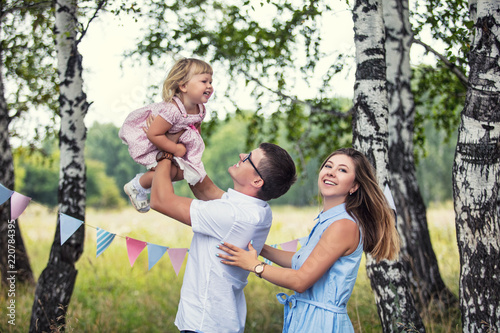 Family mother, father and little daughter beautiful and happy outdoors in the Park celebrating a holiday © kuzmichstudio