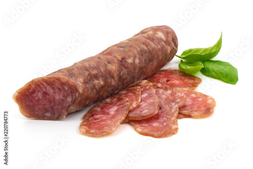 Smoked sausage with thin slices and green basil leaves, isolated on white background