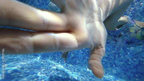 Young girl dive underwater in blue swimming pool. Slow motion 120 FPS.