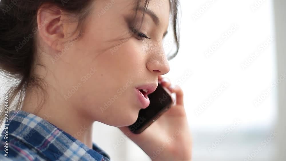 Happy woman talking on mobile phone in living room at home Happy woman talking on mobile phone in living room at home