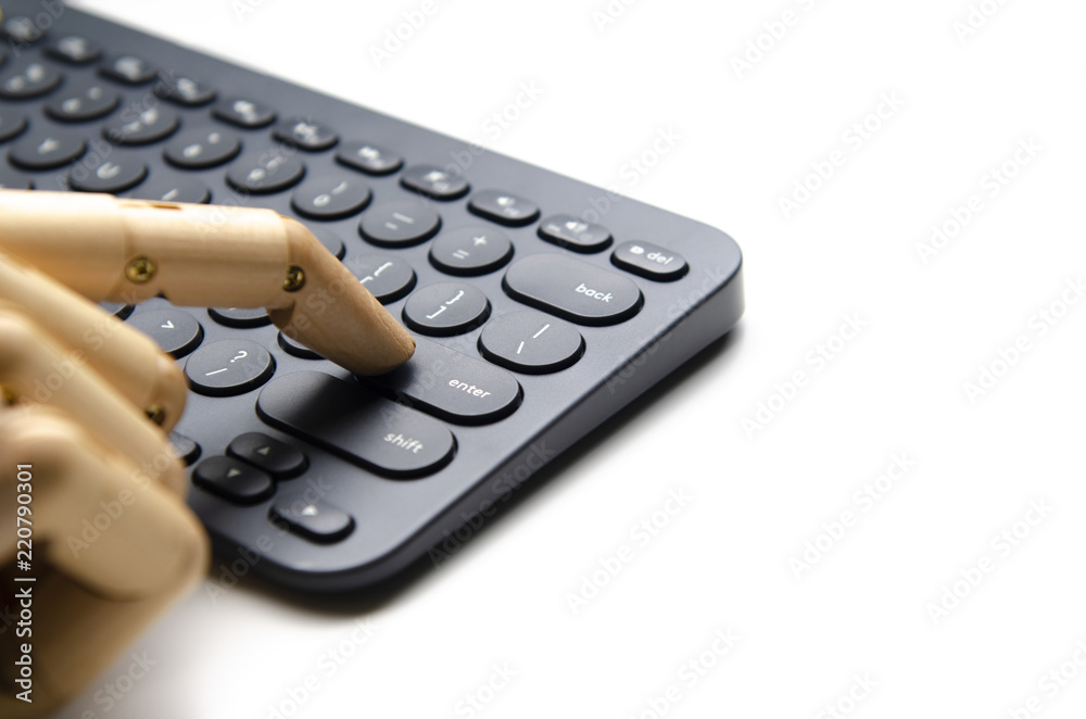 Wooden hand press enter button on black keyboard for technology concepthand Wooden hand press enter button on black keyboard for technology concepthand