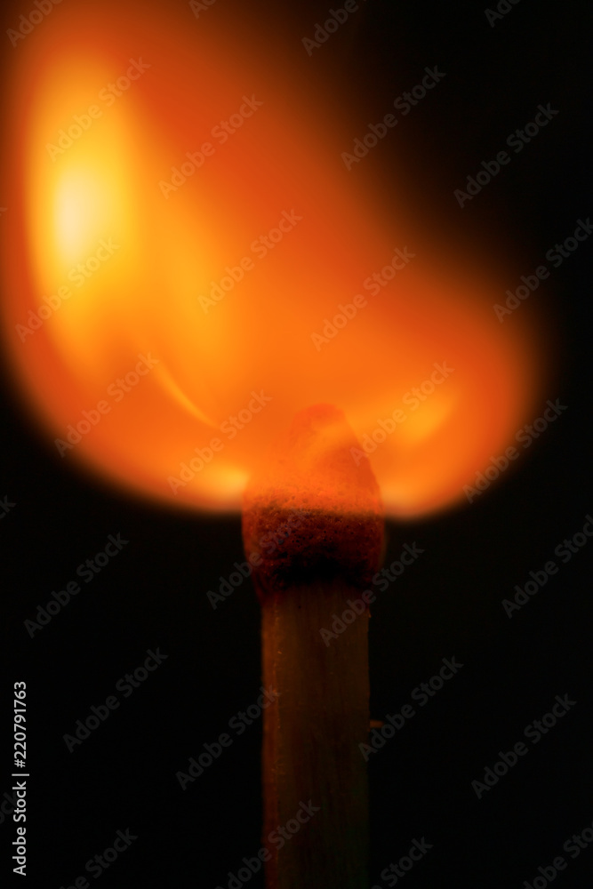 burning match in the dark / match fire on a black background close-up burning match in the dark / match fire on a black background close-up