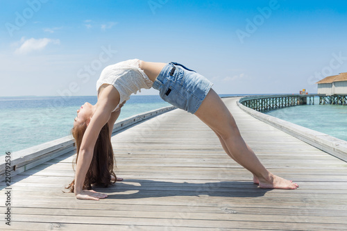 Healthy Asian woman relaxing in yoga bridge Pose on wooden bridge on the beach in Maldives,Feeling so comfortable and relax in holiday,Healthy Concept
