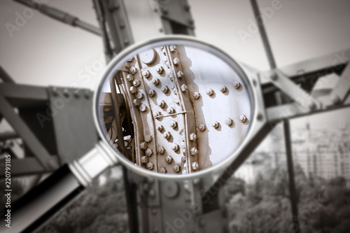 Control and surveillance of the conservation status of a metal structure - Detail of an old metal structure of the nineteenth century seen through a magnifying glass - concept image photo