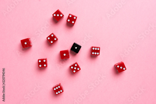 Red and black gaming dices on pink background. Flat lay, game concept.