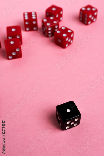 Red and black gaming dices on pink background. Game concept.
