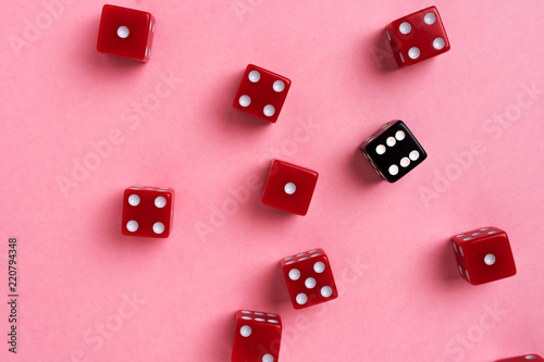 Red and black gaming dices on pink background. Flat lay, game concept.