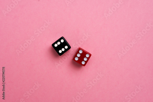 Red and black gaming dices on pink background. Flat lay, place for text. Game concept