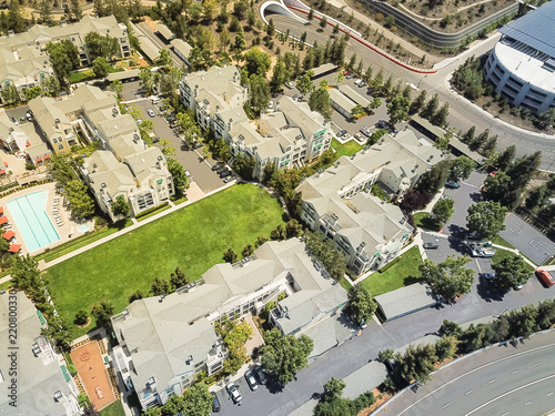 Aerial view typical multi-level apartment homes with swimming pool near freeway in Silicon Valley, California photo