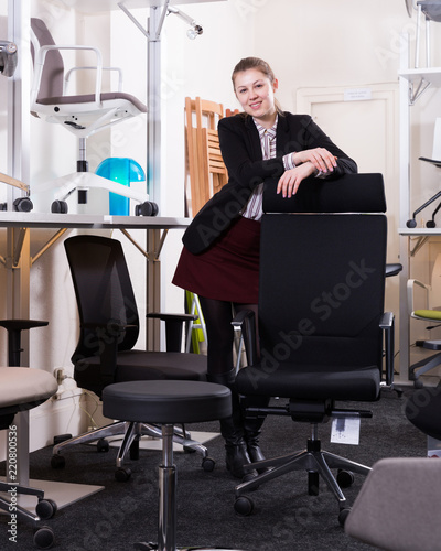 Smiling girl standing in chair shop photo