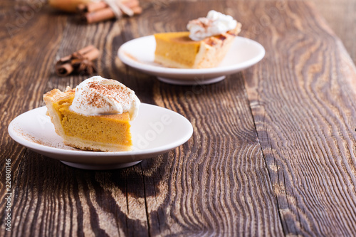 Slices of pumpkin pie with whipped cream on top, close-up
