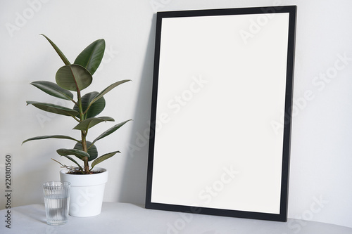Poster in black frame in nordic stylish modern interior, ficus, living room. Empty space for design layout.