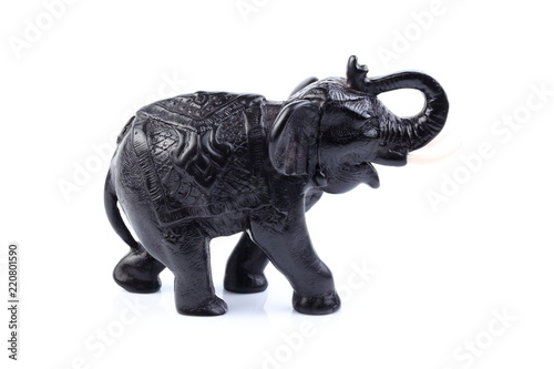 Black Engraved pattern elephant made of resin like wooden carving with white ivory. Stand on white background, Isolated, Art Model Thai Crafts, For decoration Like in the spa. © Thanachai