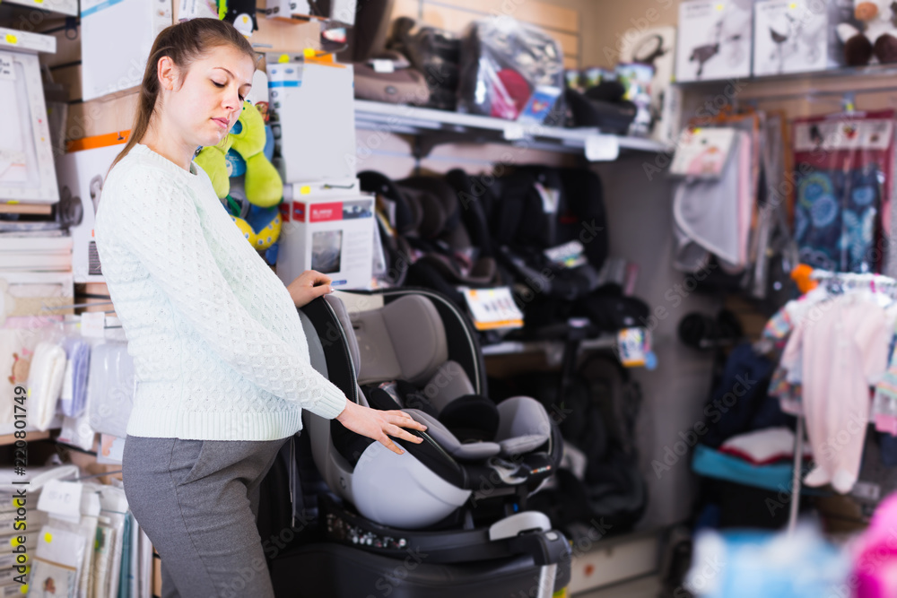 Pregnant woman customer is looking baby seat for car