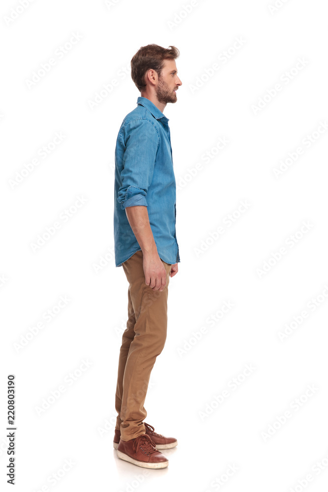 side view of a young casual man standing Stock Photo