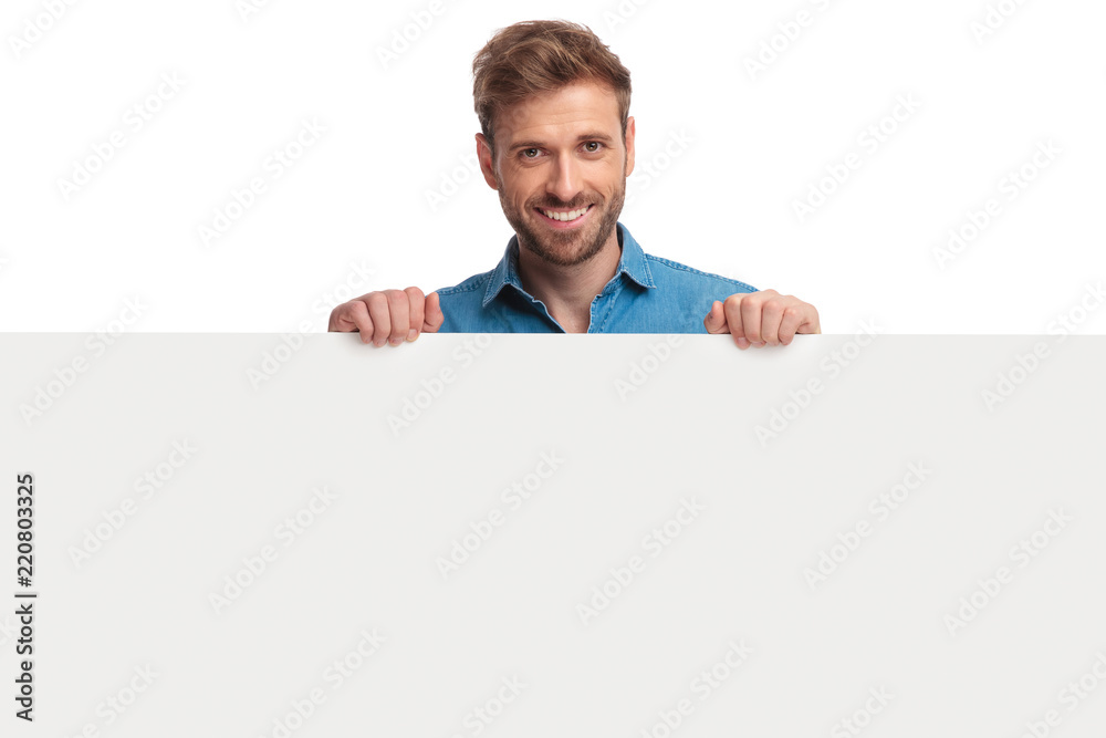 smiling young casual man presenting a blank board smiling young casual man presenting a blank board