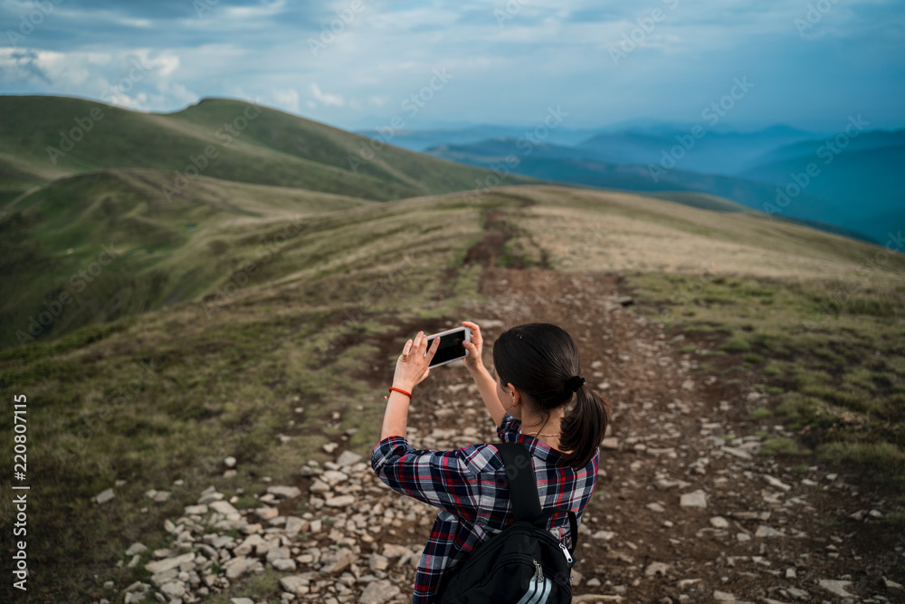 Tourist is taking photo of amazing view on cell phone. Carpathians, Ukraine