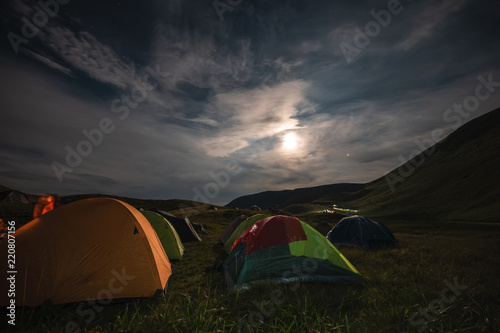 Tourists rest at night in tents under the starry sky in the mountains. Carpathians, Ukraine