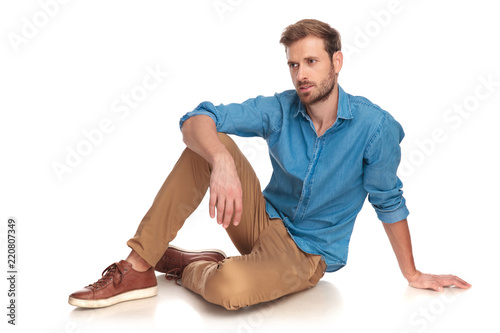 фотографія side view of a fashion man sitting down