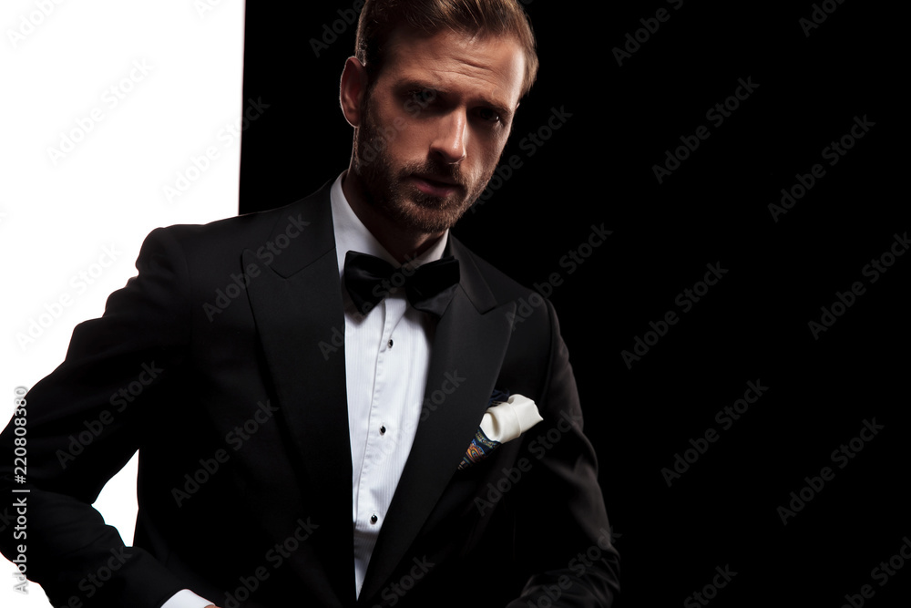 Obraz premium young businessman in tuxedo and bowtie posing