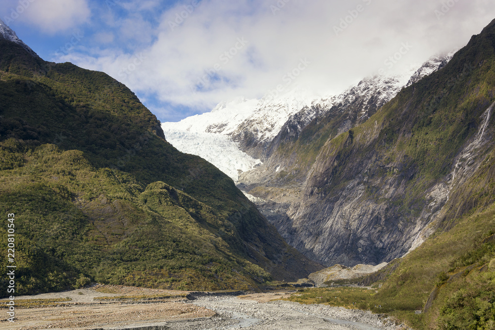 View on the scenic panorama of the Franz Josef Glacier on the west coast of New Zealand. Ice, rocks, valley, beautiful sky, trees and bare ground are all available. A beautiful touristic destination
