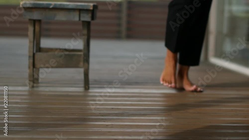 A woman walking barefoot on a wooden floor