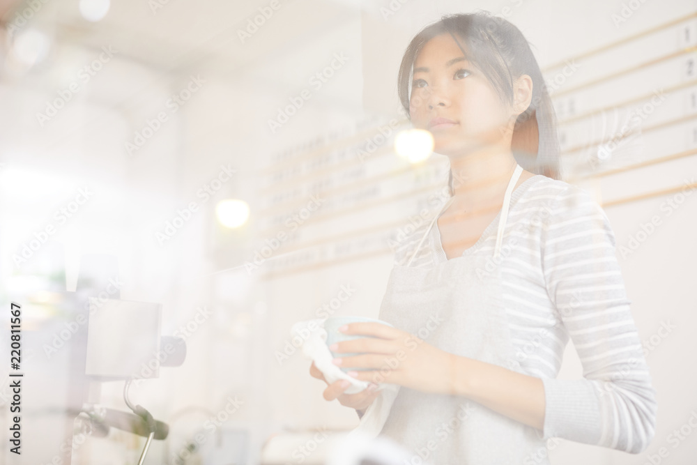 Young worker of cafeteria standing by cashier counter and preparing drink for client Young worker of cafeteria standing by cashier counter and preparing drink for client