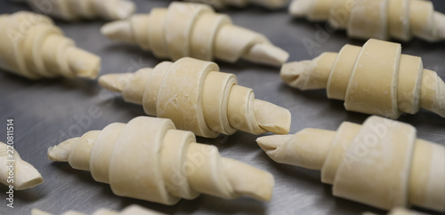 Fotografie Frozen pieces for croissants on a baking sheet in a bakery