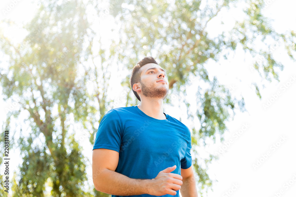 Focused Runner Practicing Running In Park On Sunny Day Focused Runner Practicing Running In Park On Sunny Day