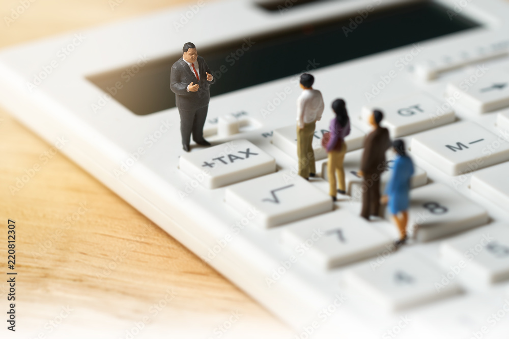 Miniature people Pay queue Annual income (TAX) for the year on calculator. using as background business concept and finance concept with copy space for your text or design. Miniature people Pay queue Annual income (TAX) for the year on calculator. using as background business concept and finance concept with copy space for your text or design.