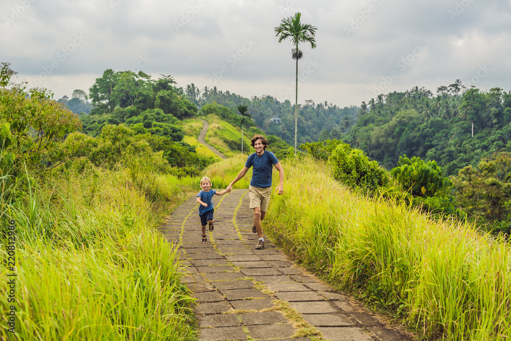 Obraz premium Dad and son tourists in Campuhan Ridge Walk , Scenic Green Valley in Ubud Bali. Traveling with children concept