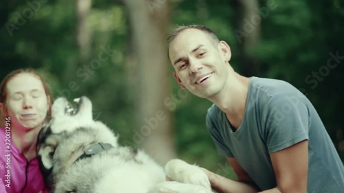 A man in park stroking a dog photo