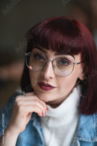Portrait of young redhead with denim jacket turtle neck and glasses