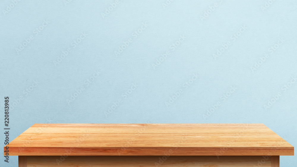 Empty wooden tabletop isolated on blue wall background. For your product placement or montage with focus to the table top in the foreground. Empty pine wooden shelf. shelves