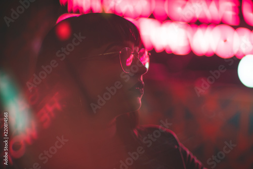 Young redhead dancer with glasses on neon lights