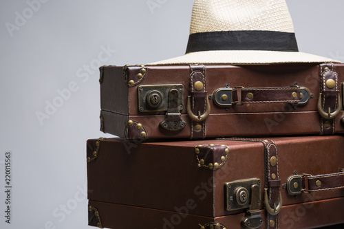 Close-up of straw hat on old suitcase. Old suitcase for traveling