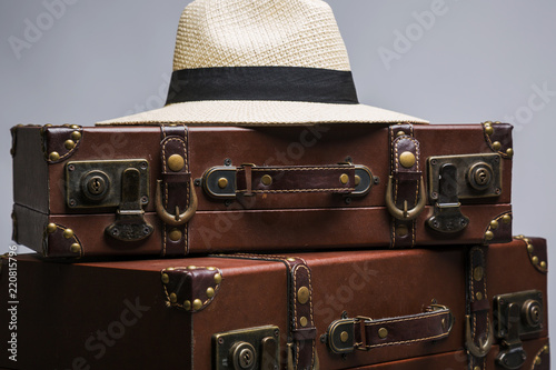 Close-up of straw hat on old suitcase. Old suitcase for traveling