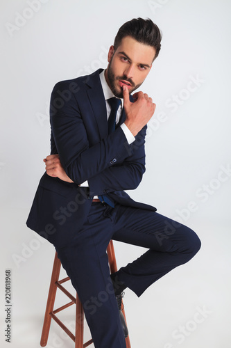 portrait of sexy businessman sitting and touching his lips