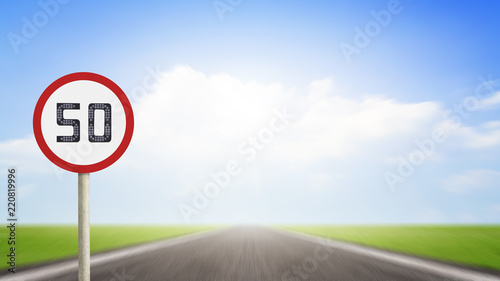 Traffic number 50 or Speed limit road sign on blurred asphalt road with colorful light background. Transport Concept