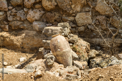 Old jug near stone wall, archaeological park of Shiloh, Israel