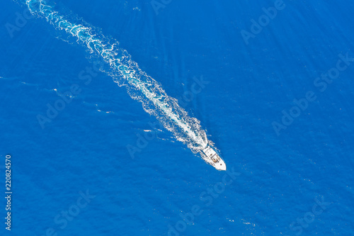 Luftaufnahme eines Motorbootes welches über türkis blaues Meer fährt