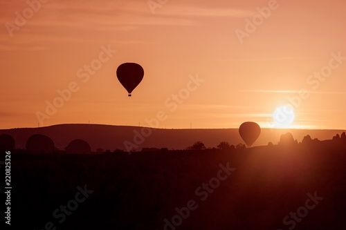 silhoutte of balloon on sunrise. famous hot air balloon flying over valley. Goreme, Cappadocia, Turkey.