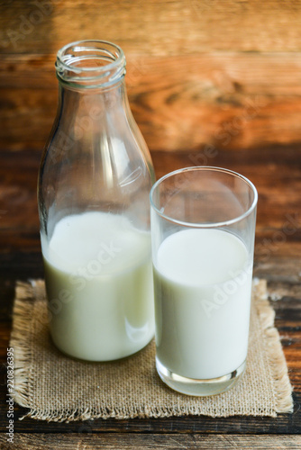 glass of milk, cow on natural wooden background in rustic style, rural style, concept of natural products and farming