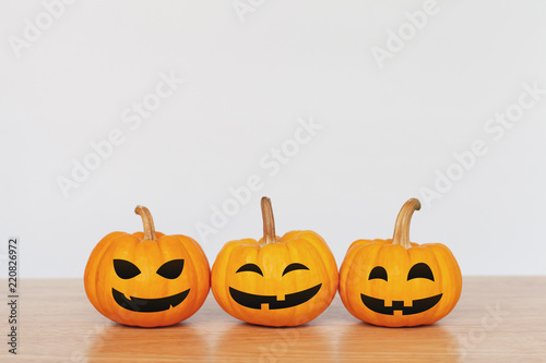 Pumpkins on wood table with white background. Halloween and decoration concept. Front view and copy space