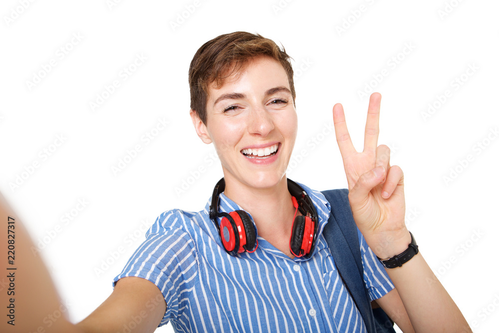 happy young woman taking selfie with peace hand sign on isolated white background happy young woman taking selfie with peace hand sign on isolated white background