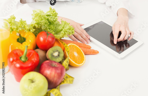 Female nutritionist working on digital tablet